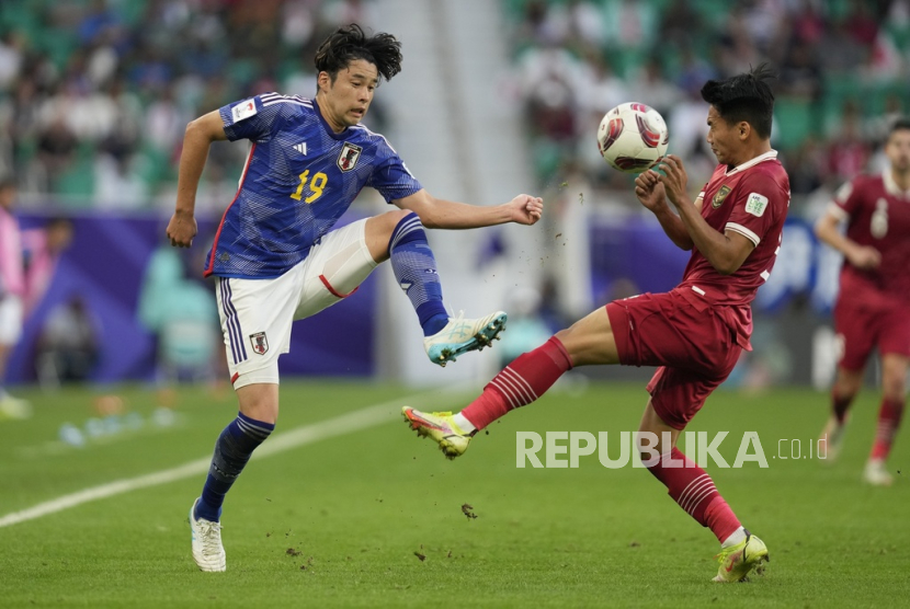 Jepang Yuta Nakayama berebut bola dengan pemain Indonesia pada pertandingan sepak bola Grup D Piala Asia antara Jepang dan Indonesia di Al Thumama di Doha, Qatar, Rabu, (24/1/2024).