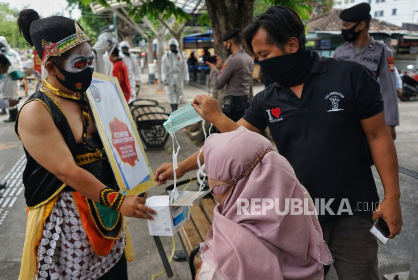 Petugas membagikan masker kepada warga saat kampanye pemakaian masker di kawasan Malioboro, Yogyakarta, (ilustrasi).