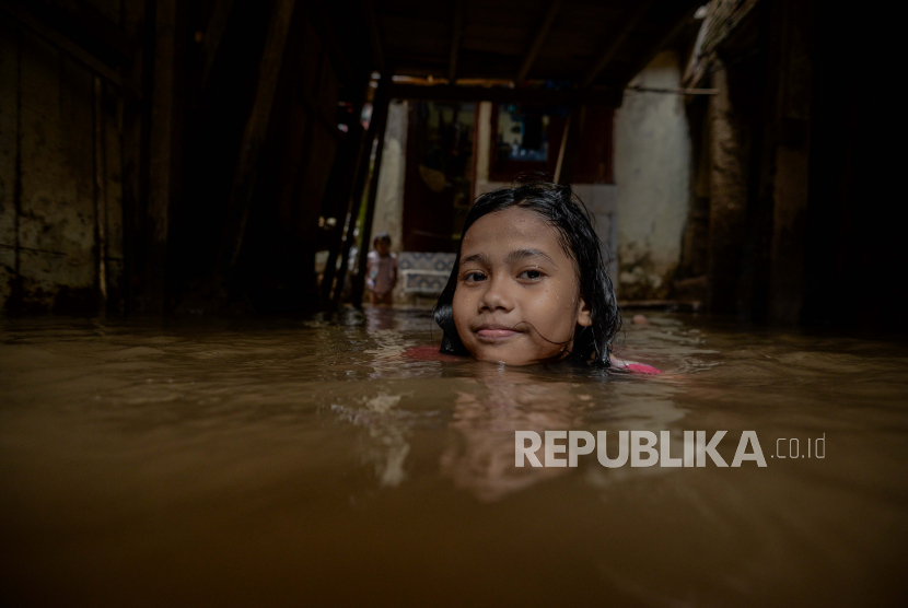Anak bermain di area pemukiman yang terendam banjir di kawasan Kebon Pala II, Jakarta, Rabu (3/2). Banjir tersebut terjadi akibat luapan kali Ciliwung setelah tingginya curah hujan pada Rabu (3/2) dini hari dengan ketinggian berkisar 10-20 centimeter . Republika/Thoudy Badai