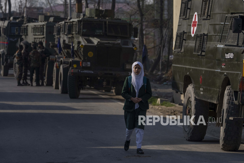Seorang siswi Kashmir berjalan melewati kendaraan tentara India (IIlutrasi). Islamofobia anti-Muslim sudah merambah ke film-film produksi India 