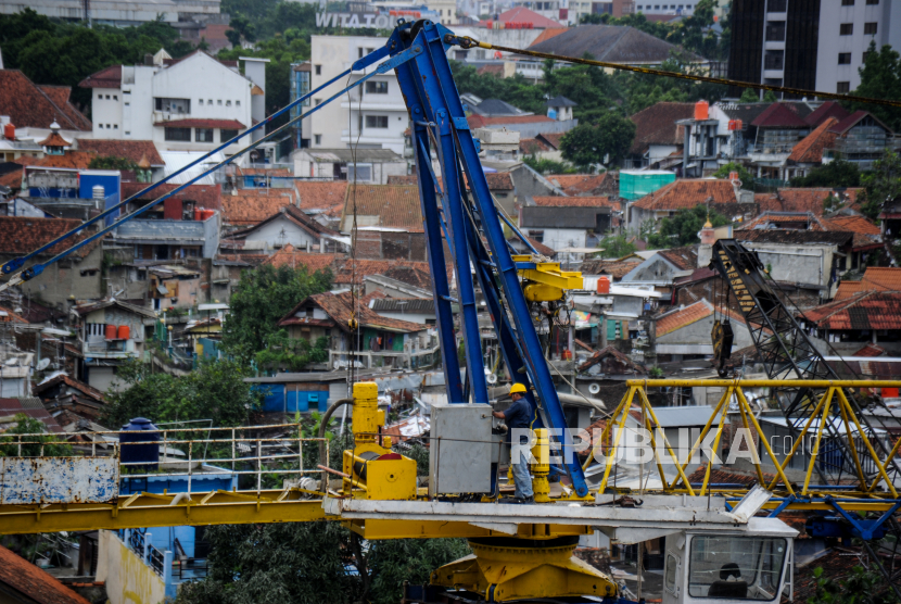 Pekerja beraktivitas di atas crane proyek pembangunan rumah deret, Tamansari, Bandung, Jawa Barat, Jumat (18/12/2020). Lembaga Pengembangan Jasa Konstruksi (LPJK) mencatat, jumlah tenaga kerja konstruksi yang sudah memiliki sertifikat kompetensi kerja hingga November 2020 sebanyak 641.595 pekerja atau sebanyak 7,54 persen dari jumlah sekitar 8,5 juta tenaga kerja konstruksi Indonesia. 
