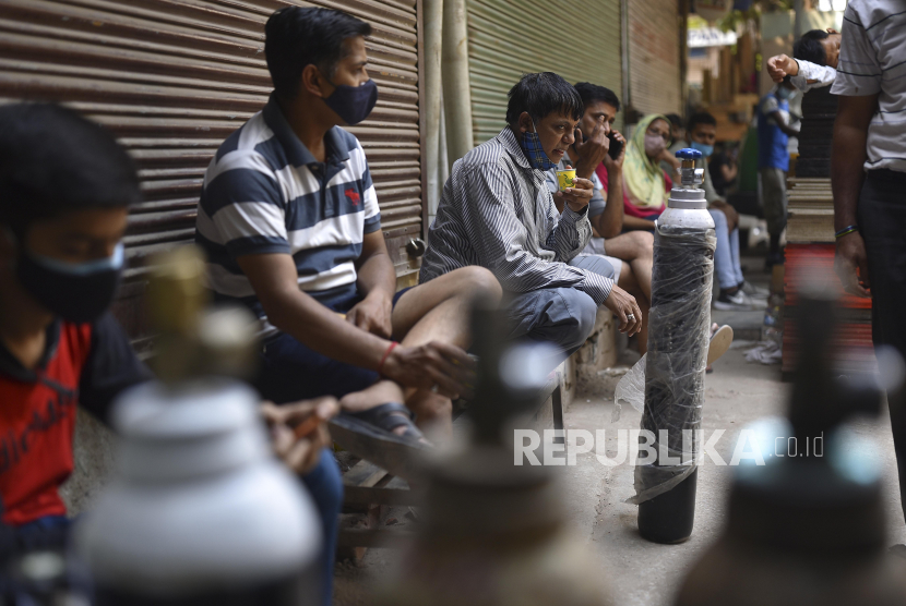 Sejumlah warga menunggu untuk mengisi tabung oksigen di New Delhi, India, Kamis (29/4). Delhi melaporkan 25.986 kasus baru, 368 kematian dalam 24 jam terakhir dan terus berjuang dengan pasokan oksigen yang ada.  EPA-EFE/IDREES MOHAMMED