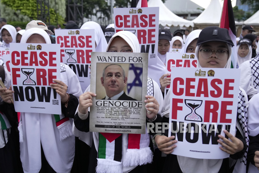 Seorang pengunjuk rasa memegang poster Perdana Menteri Israel Benjamin Netanyahu saat unjuk rasa mendukung Palestina di luar Kedutaan Besar AS di Jakarta, Indonesia, Sabtu, 13 Januari 2024. 