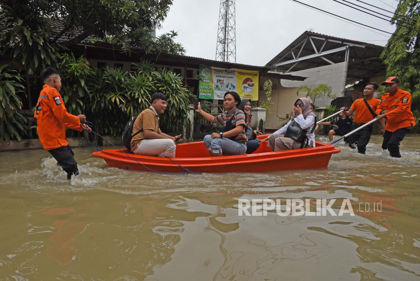 Petugas BPBD (Badan Penanggulangan Bencana Daerah) Provinsi Banten menolong warga melewati banjir di Kota Serang. BPBD Kota Serang sebut ada 15 titik banjir dan paling tinggi sedalam 1 meter.