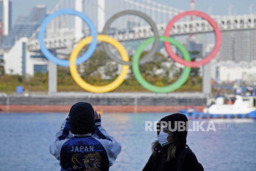  Orang-orang melihat pemasangan ulang monumen cincin Olimpiade di tepi laut Taman Laut Odaiba, di Tokyo, Jepang, akhir 2020 lalu (ilustrasi). Jepang membantah kabar Olimpiade Tokyo dibatalkan.