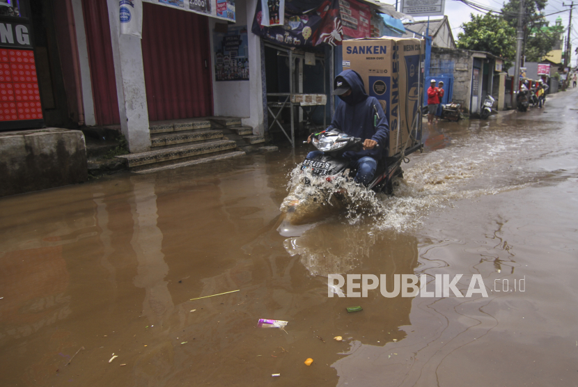 Pengendara melintasi genangan banjir di Kampung Utan, Citayem, Depok, Jawa Barat, Senin (8/2/2021). Banjir setinggi 30 cm - 50 cm tersebut disebabkan karena meluapnya aliran kali dan hujan deras yang mengguyur Kota Depok. 