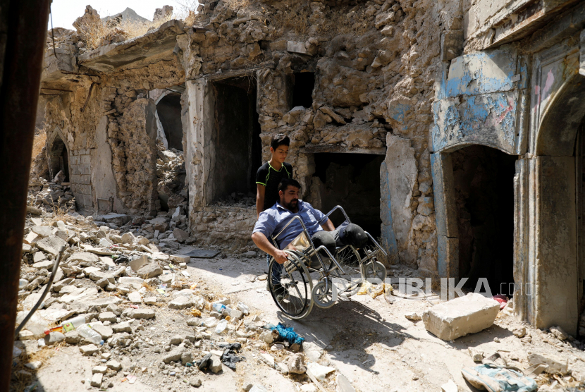  Mohammed Sattar, seorang pria Irak yang mengatakan bahwa dia kehilangan kedua kakinya selama pertempuran untuk merebut kembali Mosul dari militan ISIS, duduk di kursi roda ketika dia terlihat di samping rumahnya yang hancur di kota tua Mosul, Irak, 31 Agustus, 2020.
