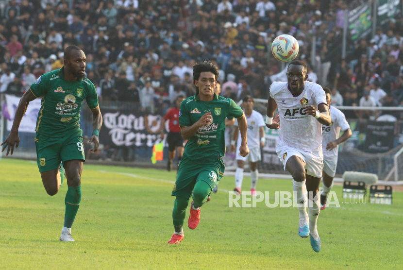 Pesepak bola Persik Kediri Flavio Antonio Da Silva (kanan) berebut bola dengan pesepak bola Persebaya Surabaya Ripal Wahyudi (tengah) dalam pertandingan kompetisi Liga 1 di Stadion Brawijaya, Kota Kediri, Jawa Timur, Jumat (27/10/2023). Persik Kediri menang dengan skor 4-0.  