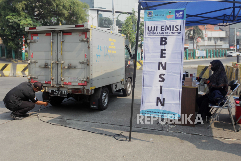 Petugas melakukan uji emisi kendaraan mobil yang terjaring uji coba tilang uji emisi di Terminal Blok M, Jakarta Selatan, Jumat (25/8/2023).