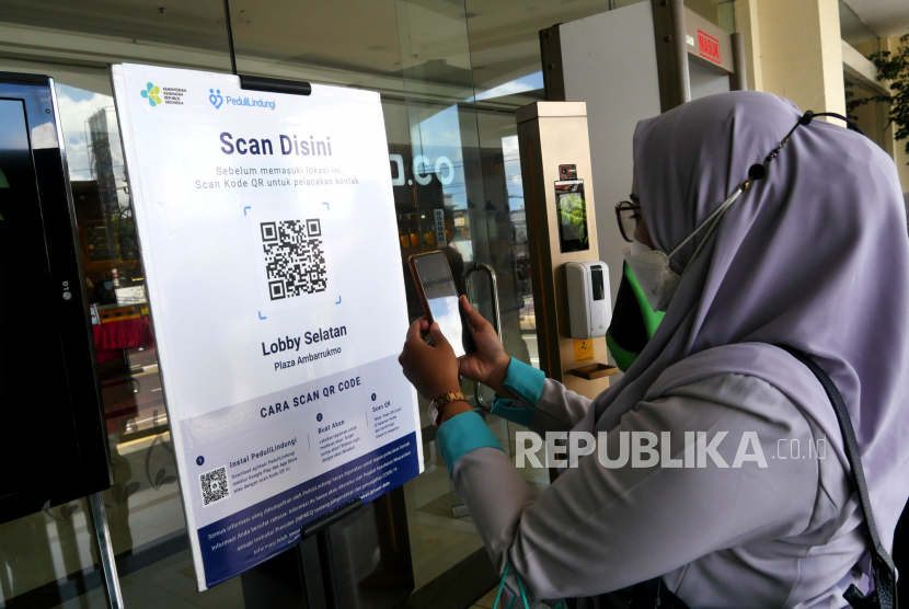 Warga memindai barcode sebelum memasuki pusat perbelanjaan Ambarukmo Plaza, Sleman, Yogyakarta, Selasa (25/8). Kabupaten Sleman mulai melakukan uji coba pembukaan pusat perbelanjaan atau mal saat perpanjangan PPKM Level 4. Untuk pengunjung dibatasi usia di atas 12 tahun dan di bawah 70 tahun. Serta pengunjung wajib vaksin dibuktikan melalui skrining menggunakan aplikasi Peduli Lindungi di pintu masuk.