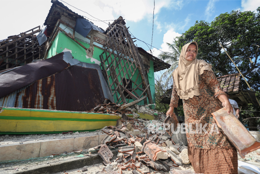 Warga membereskan puing-puing rumah yang rusak akibat terdampak gempa di Sangkapura, Pulau Bawean, Kabupaten Gresik, Jawa Timur, Ahad (24/3/2024). 