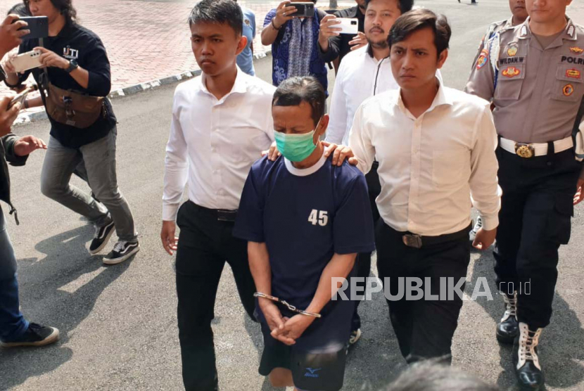 Polisi tengah menggiring ADR (52 tahun) oknum guru ngaji yang mencabuli belasan santri di Kabupaten Bandung, Senin (29/5/2023). Dok Republika