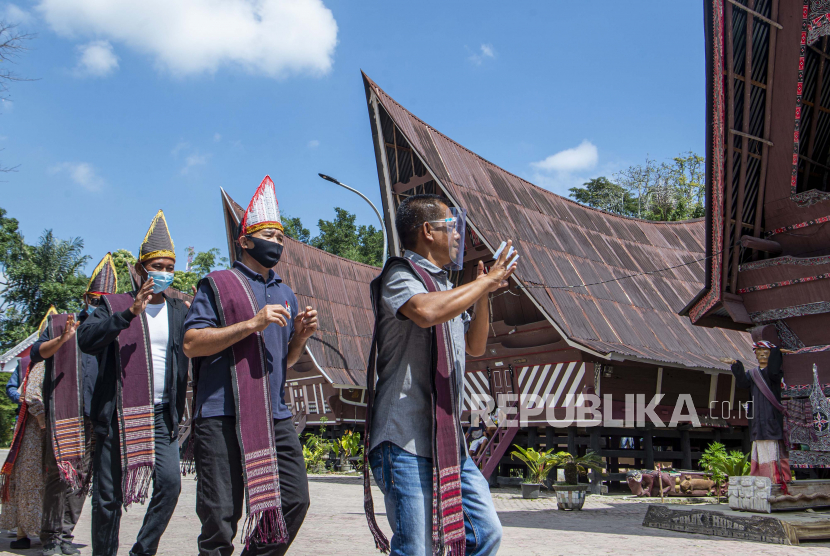 Wisatawan menari tarian tor tor di depan patung Sigale-gale di Desa Wisata Tomok, Simanindo, Samosir, Sumatera Utara. Pemerintah segera menata kawasan Tomok Samosir untuk mendukung wisata Danau Toba.