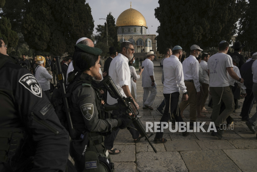 Polisi Israel mengawal pengunjung Yahudi yang menandai hari raya Paskah ke kompleks Masjid Al-Aqsa, yang dikenal umat Islam sebagai Tempat Suci Mulia dan bagi orang Yahudi sebagai Temple Mount, di Kota Tua Yerusalem selama bulan suci Ramadhan, Ahad (9/4/2023). Liga Arab dengan tegas mengecam penyerangan oleh polisi Israel