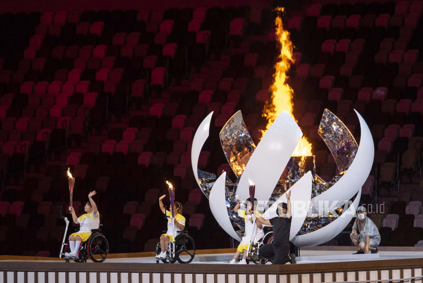  Tiga atlet menyalakan api saat upacara pembukaan pada upacara pembukaan Paralimpiade Musim Panas Tokyo 2020 di Stadion Nasional di Tokyo, Jepang, Selasa (24/8). 
