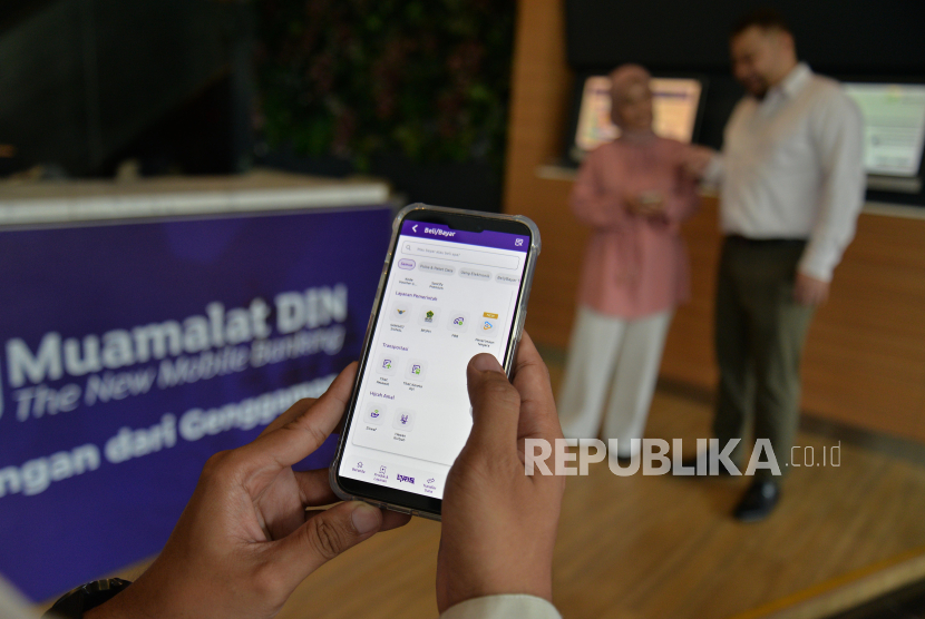 Nasabah PT Bank Muamalat Indonesia Tbk mengakses aplikasi mobile banking Muamalat DIN di Jakarta, Kamis (21/3/2024).