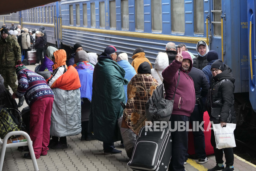 Warga Ukraina yang saat ini tinggal di Polandia berjalan di atas peron saat mereka bersiap untuk menaiki kereta Ukraina menuju Ukraina, di stasiun di Przemysl, Polandia, Senin, 7 Maret 2022. 