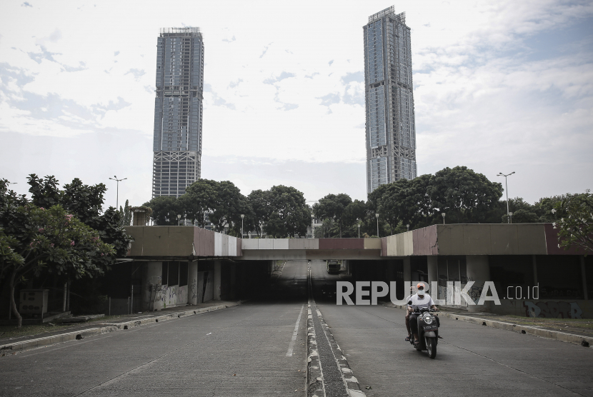 Pengendara motor melintas dengan latar gedung bertingkat di kawasan Kemayoran, Jakarta, Selasa (20/7/2021). Menteri Keuangan Sri Mulyani Indrawati mengatakan anggaran penanganan COVID-19 dan Pemulihan Ekonomi Nasional (PEN) naik menjadi Rp744,7 triliun yang meningkat 6,4 persen dari pagu anggaran semula sebesar Rp699,4 triliun. 