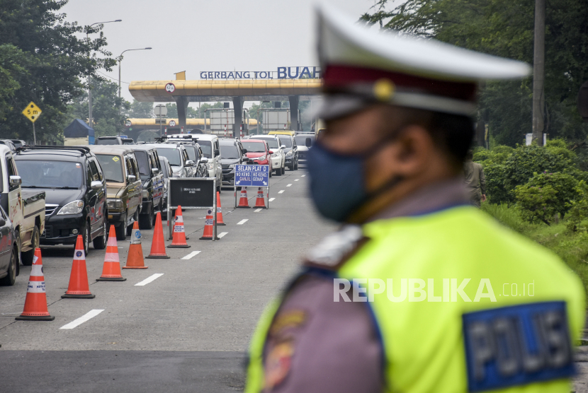 Petugas kepolisian mengatur lalu lintas saat pemberlakuan ganjil genap di gerbang Tol Buah Batu, Kota Bandung, Ahad (14/11). Pemerintah akan menerbitkan regulasi resmi terkait pengaturan mobilitas selama masa Natal dan Tahun Baru 2021/2022. 
