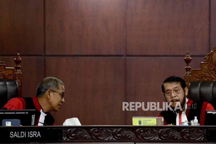 Ketua Majelis Hakim MK Anwar Usman (kanan) berbincang dengan Majelis Hakim MK Saldi Isra dalam sidang pembacaan putusan di Ruang Sidang Pleno Gedung MK, Jakarta, Senin (16/10/2023). 