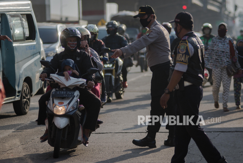 Petugas gabungan melakukan pengecekan PSBB dan mudik di kawasan Jalan Raya Kalimalang perbatasan Jakarta-Bekasi, Jawa Barat, Selasa (19/5). Lalu lintas jalur Kalimalang mengalami kenaikan volume kendaraan roda dua mencapai 1500 per hari pada H-5 hari raya idul fitri