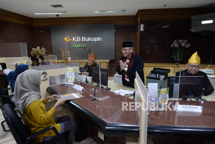 Direktur Utama PT Bank KB Bukopin Syariah (KBBS) Koko T. Rachmadi (tengah) bersama Direktur Bisnis Agus Suhendro (kiri) dan Direktur Kepatuhan & Manajemen Risiko Adil Syahputra (kanan) melayani nasabah dengan menggunakan pakaian adat Tradisional disela acara Hari Pelanggan Nasional di Banking Hall Kantor Pusat KBBS, Jakarta, Senin (4/9/2023). Kegiatan ini merupakan wujud terima kasih dan apresiasi KBBS kepada para nasabah setia yang selama ini terus mempercayakan kebutuhan finansialnya kepada KBBS. 