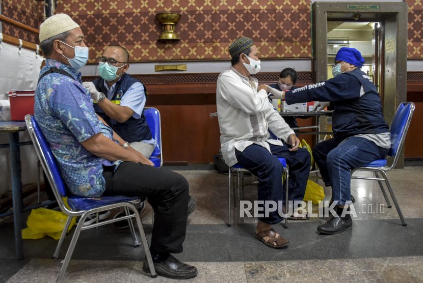 Vaksinator menyuntikkan vaksin Covid-19 jenis Pfizer kepada calon jamaah haji saat pelaksanaan vaksinasi Covid-19 dosis ketiga (booster) di Masjid Pusdai, Kota Bandung, Selasa (8/2/2022). Sebanyak 1.500 calon jamaah haji asal Kota Bandung menjalani vaksinasi Covid-19 dosis ketiga (booster) sebagai persiapan dan prasyarat keberangkatan ibadah haji ke Arab Saudi. Pemerintah Kaji Kembali Kenaikan BPIH 2022