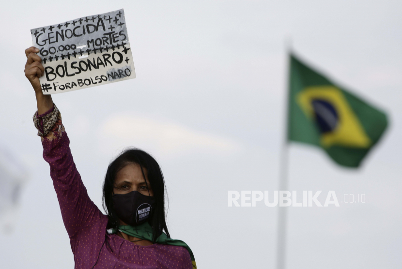  Seorang aktivis gerakan perempuan memegang tanda yang bertuliskan dalam bahasa Portugis 