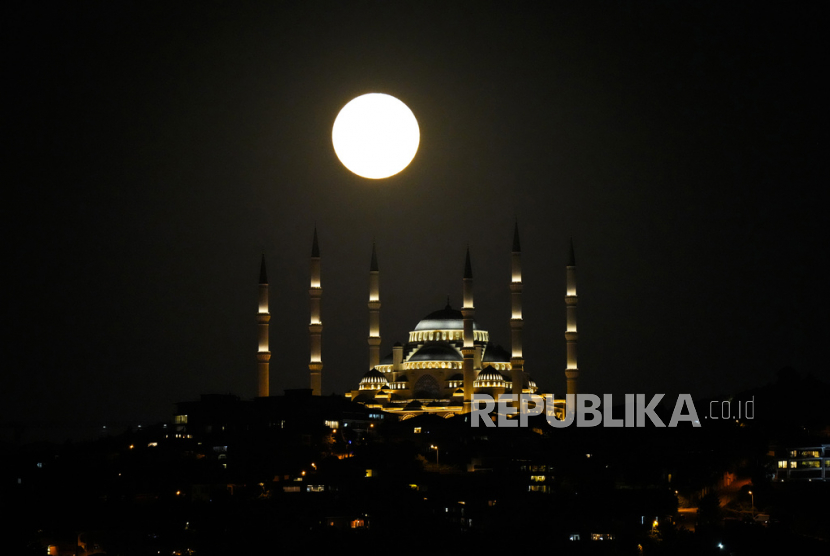 Bulan purnama super terbit di belakang masjid Camlica di Istanbul, Turki, Senin, (3/7/2023).