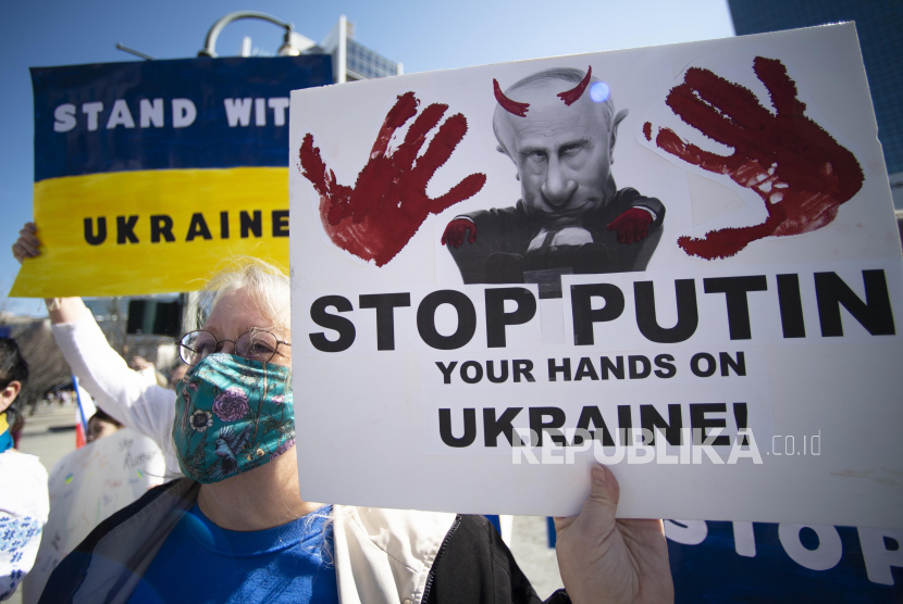 Demonstran Ukraina memegang tanda, bendera, dan papan poster saat mereka memprotes invasi Ukraina oleh Rusia, Sabtu, 26 Februari 2022, di Atlanta.