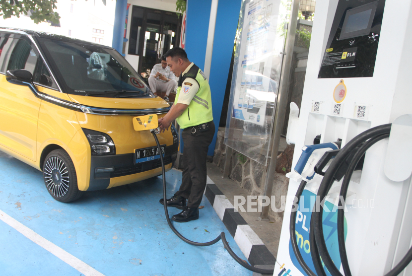 Seorang petugas membantu pengisian ulang mobil listrik milik konsumen di Stasiun Pengisian Kendaraan Listrik Umum (SPKLU) PLN UP3 Kota Malang, Jawa Timur, Rabu (3/1/2024). 