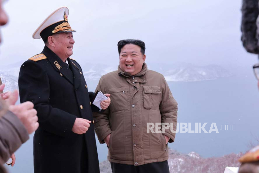  Pemimpin Korea Utara Kim Jong Un (tengah) sedang mengawasi uji coba rudal jelajah strategis yang baru dikembangkan yang diluncurkan dari kapal selam pada 28 Januari 2024.