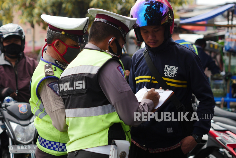 Aparat gabungan dari Polsek Bandung Kidul dan Satpol PP Kecamatan Bandung Kidul merazia warga yang tidak mengenakan masker di kawasan Pasar Kordon, Bandung,  Jumat (14/8). Pelanggar didata dan diimbau untuk menaati protokol kesehatan dengan mengenakan masker saat bepergian. FOTO YOGI ARDHI