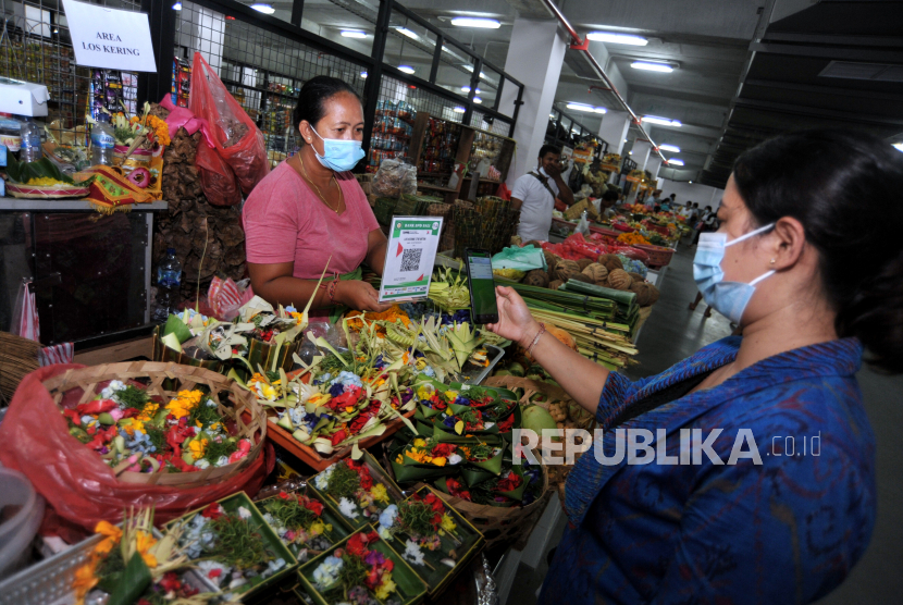 Warga melakukan transaksi pembayaran berbasis digital di pasar Buleleng, Bali. Hal ini untuk meningkatkan daya saing pasar tradisional serta meminimalisir terjadinya kontak fisik guna mencegah penyebaran COVID-19. 