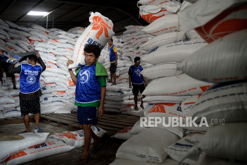 Pekerja mengangkat beras saat bongkar muat di pasar  (ilustrasi)