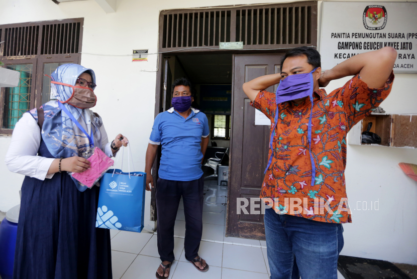 Aparatur Gampong (Desa) memakai masker bantuan dari Balai Latihan Kerja (BLK) Banda Aceh di Desa Geuceu Kaye Jato, Banda Aceh, Aceh, Rabu (1/4/2020). Peserta latihan kerja menjahit ribuan masker untuk diserahkan kepada warga, pedagang kaki lima pasar Keutapang dan tenaga medis RSU Meuraxa guna mengantisipasi penyebaran virus Corona (COVID-19)