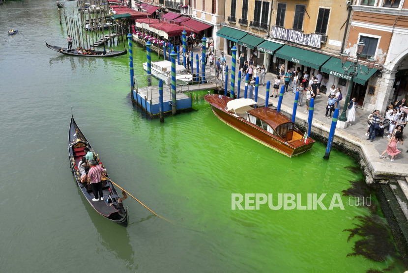 Air di Kanal Besar dekat Jembatan Rialto, di Venesia, Italia, Ahad (28/5/2023) terlihat berubah warna menjadi hijau. Pemerintah setempat tengah menyelidiki penyebab dari peristiwa ini. Otoritas lingkungan terkait juga sudah mengambil sampel air untuk dilakukan pengujian.
