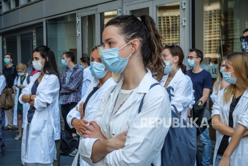 Penghuni khusus medis lulusan ARS-CoPost mengenakan masker saat mereka mengambil bagian dalam protes di depan kursi pemerintah daerah Lombardy untuk menuntut perbaikan kondisi dan perlindungan di tempat kerja, serta pengakuan pemerintah atas pekerjaan mereka selama pandemi yang sedang berlangsung dari penyakit COVID-19 yang disebabkan oleh coronavirus SV-2 di Milan, Italia utara, 22 Juni 2020.