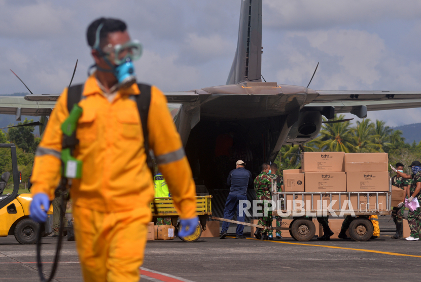 Prajurit TNI mengangkat kardus berisi Alat Perlindungan Diri (APD) untuk penanganan COVID-19 di Bandara Sam Ratulangi, Manado, Kamis (26/3/2020). Pemerintah Provinsi Sulawesi Utara menerima sekitar 3
