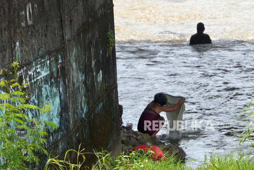 Warga mencuci pakaian di Sungai Code, Yogyakarta, Kamis (19/1/2023). Badan Pusat Statistik (BPS) mencatat jumlah penduduk miskin di Indonesia pada Maret 2023 mencapai 25,90 juta orang.