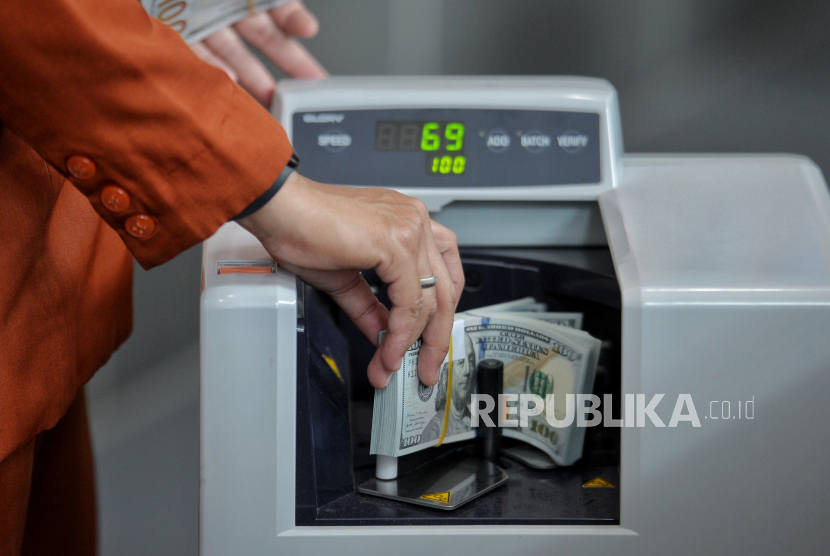 Petugas menghitung uang dollar AS di tempat penukaran valuta asing PT Valuta Inti Prima di Cikini, Jakarta, Selasa (21/11/2023). 