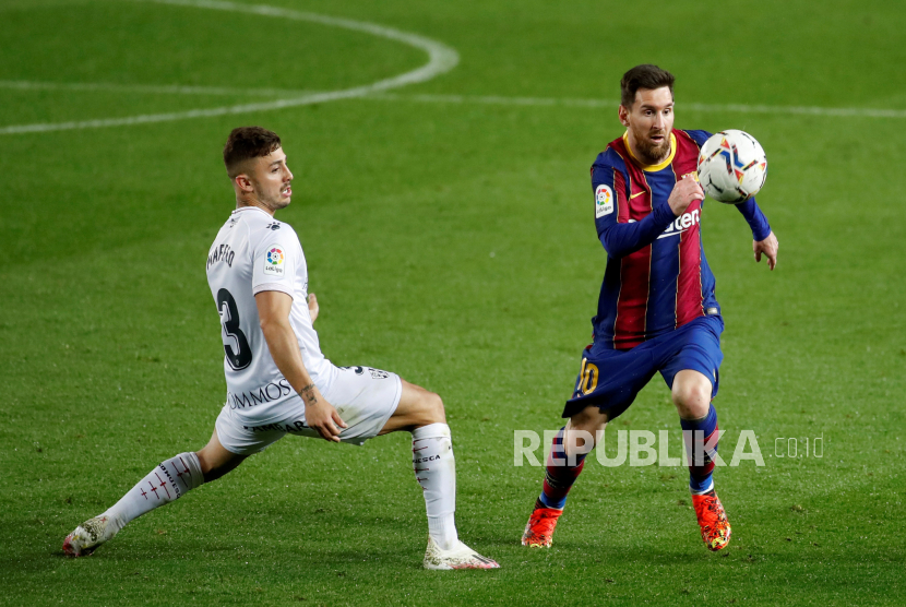  Striker FC Barcelona Leo Messi (kanan) bersaing memperebutkan bola dengan bek Huesca Pablo Maffeo (kiri) selama pertandingan sepak bola LaLiga Spanyol antara FC Barcelona dan SD Huesca yang diadakan di stadion Camp Nou, di Barcelona, ??Catalonia, Spanyol, 15 Maret 2021.