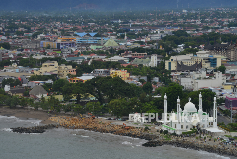 Sejumlah pekerja menggunakan alat berat memindahkan batu grip di tepi Pantai Padang, Sumatera Barat, Selasa (11/7/2023). Kementerian PUPR melalui Balai Wilayah Sungai Sumatera V tahun ini melakukan penanganan abrasi di Pantai Padang dengan menyusun batu grip untuk pengamanan pantai di sekitar Masjid Al Hakim. 