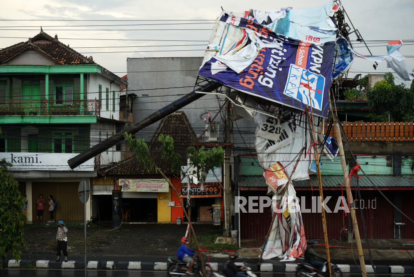 Polisi berjaga di dekat baliho yang roboh akibat diterjang angin kencang di kawasan Condongcatur, Sleman, D.I Yogyakarta, Kamis (03/02/2022). Tidak ada korban jiwa dalam peristiwa yang mengakibatkan jaringan listrk padam di daerah tersebut. 
