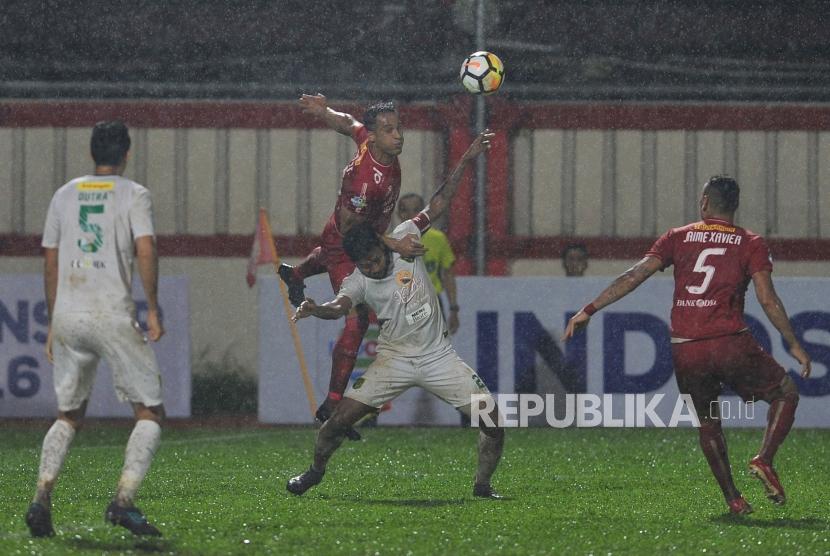 Penyerang Persija Jakarta Addison Alves berduel udara dengan pemain Persebaya Fandry Imbiri dalam laga lanjutan Liga 1 2018 di Stadion PTIK, Jakarta Selatan, Selasa (26/6).