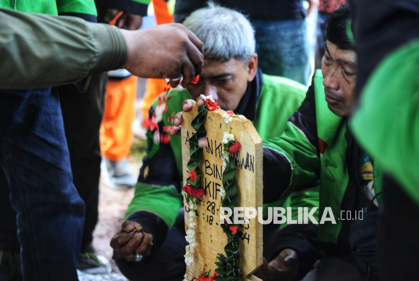 Para kerabat menaburkan bunga di makam Affan Kurniawan (21) di TPU Karet Bivak, Jakarta, Jumat (29/8/2025). Affan Kurniawan yang merupakan driver ojek online tersebut meninggal dunia setelah dilindas mobil kendaraan taktis (Rantis) Brimob saat terjadinya bentrok dengan polisi di kawasan Pejompongan, Jakarta.