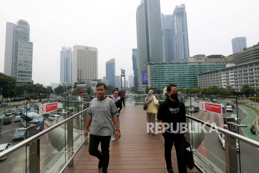 Orang Indonesia berjalan di Jakarta, Indonesia, 28 November 2022. Pemerintah memperkirakan pertumbuhan ekonomi nasional sampai akhir 2022 berada pada angka 5,2 persen secara tahunan