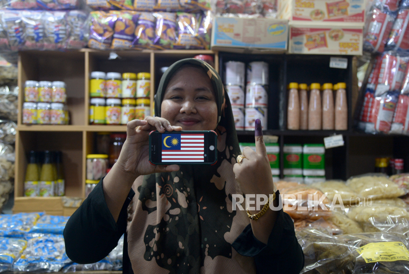 Seorang pedagang menunjukkan jari yang telah dicoblos dakwat di tokonya Pasar Siti Khadijah usai pemungutan suara di Kota Bharu, Kelantan, Malaysia, Sabtu (19/11/2022). Warga Malaysia melaksanakan Pilihan Raya Umum ke-15 (Pemilu) untuk menentukan pemerintahan selanjutnya hingga lima tahun ke depan. ANTARA FOTO/ Rafiuddin Abdul Rahman/rwa.