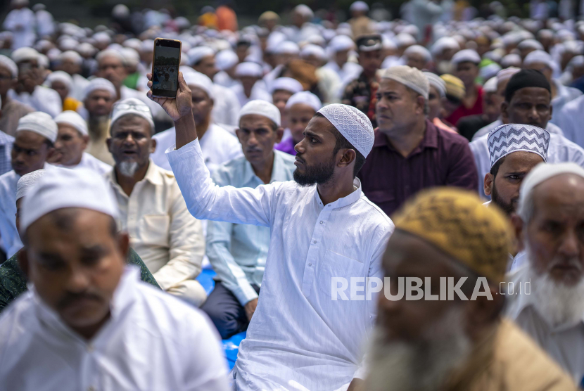  Seorang pria merekam video saat umat Islam melaksanakan salat Idul Fitri di Gauhati, India, Selasa, 3 Mei 2022. Idul Fitri menandai berakhirnya bulan puasa Ramadhan.
