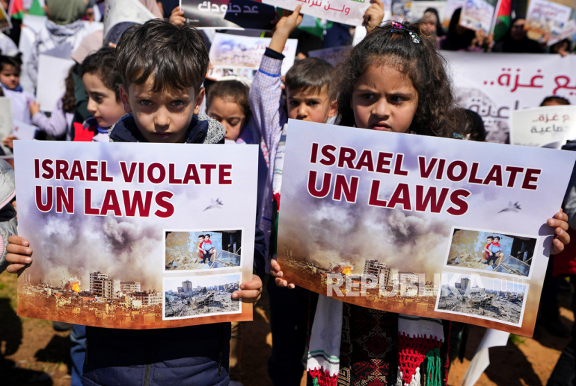 Warga Palestina yang tinggal di Lebanon memegang plakat saat protes menuntut gencatan senjata dan mendukung warga Palestina di Jalur Gaza, di Beirut, Lebanon, Kamis, (29/2/2024). 
